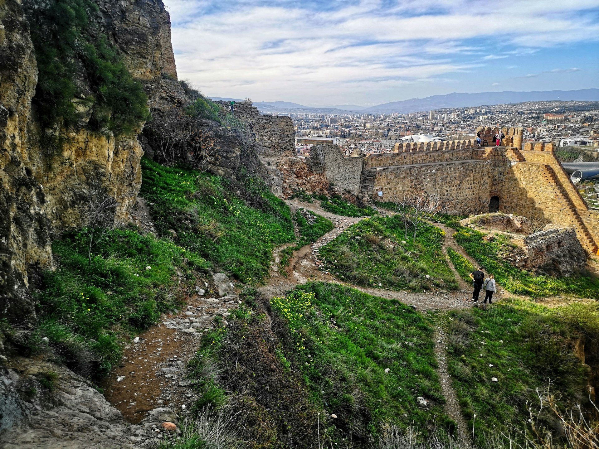a stone wall with a city in the background